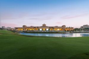 une vue d'un terrain de golf avec un grand bâtiment dans l'établissement Madinaty Stylish furnished 1 bedroom Apartment-شقة فندقيه للايجار مدينتي, à Madinaty
