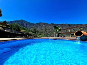 a large blue swimming pool with mountains in the background at Laurelin in Candelaria