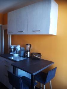 a kitchen with a table with two chairs and a cabinet at Kilian Campus UGA in La Tronche