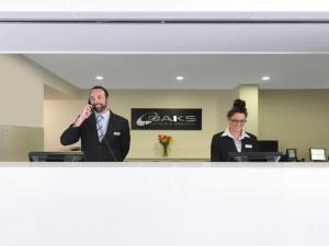 two people in an office talking on a microphone at Oaks Mackay Carlyle Suites in Mackay