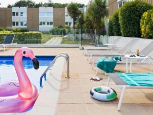 une piscine avec un flamingo rose et une piscine dans l'établissement Novotel Rennes Alma, à Rennes