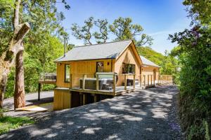 uma cabana na floresta com uma entrada em Tresillian Lodge Waterfront, Forest, Hot tub,Sauna em Truro