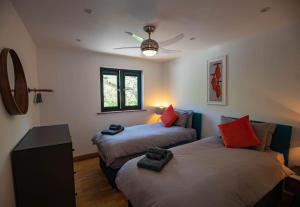 um quarto com 2 camas e uma ventoinha de tecto em Tresillian Lodge Waterfront, Forest, Hot tub,Sauna em Truro