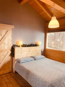 スビアーコにあるNido del Nibbioのベッドルーム1室(ベッド1台、ランプ2つ、窓付)