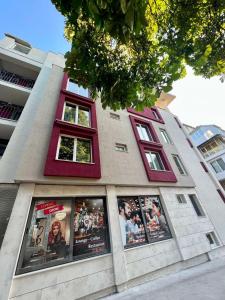 a building with red windows and posters on it at Floral Boutique Hotel in Pleven