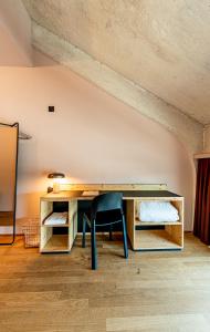 Habitación con escritorio de madera y silla. en Silo Design & Boutique Hostel Basel en Basilea
