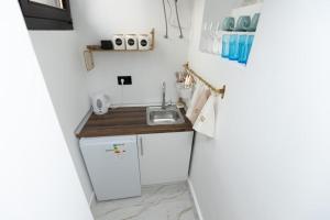 a small kitchen with a sink and a refrigerator at Bonsai Apartment in Novi Pazar