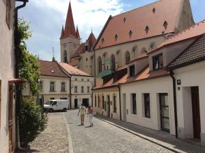 Zwei Leute laufen eine Straße entlang in einer Stadt in der Unterkunft Apartment historical city in Znojmo