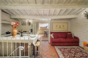 sala de estar con sofá rojo y mesa en Terrazza Silena, centro storico con vista Cortona!, en Cortona