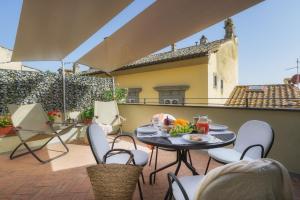 d'une terrasse avec une table et des chaises sur un balcon. dans l'établissement Terrazza Silena, centro storico con vista Cortona!, à Cortone