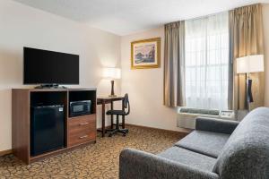 une chambre d'hôtel avec un canapé et une télévision dans l'établissement Quality Inn & Suites, à Manistique