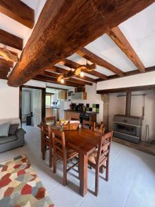 eine Küche und ein Wohnzimmer mit einem Holztisch und Stühlen in der Unterkunft Gite de l'Oeil in Saint-Pierre-de-Fursac