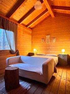 スビアーコにあるNido del Nibbioの木製の部屋にベッド2台が備わるベッドルーム1室