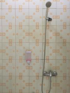 y baño con ducha y azulejos marrones y blancos. en RedDoorz near GOR Lagaligo Palopo en Palopo