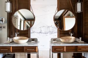 two sinks in a bathroom with two mirrors at Jumeirah Al Naseem Dubai in Dubai