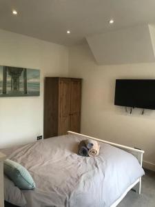 a bedroom with a bed and a flat screen tv at 4 Bedroom Flat In Watford in Leavesden Green