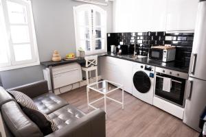 a kitchen with a couch and a microwave at Fabulous City Centre Apartment - Grand Central House in Gibraltar