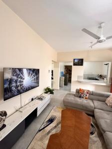 a living room with a couch and a tv on a wall at Shawell Homes in Kilifi