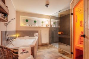 a bathroom with a tub and a shower and a sink at Baude VI - Löwenbaude Braunlage in Braunlage
