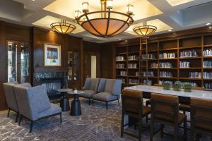 a library with chairs and a table and bookshelves at Hyatt Regency Coralville in Coralville