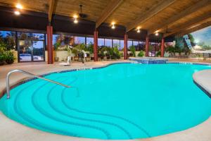 uma grande piscina com água azul num edifício em Travelodge by Wyndham Enid em Enid