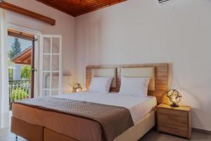 a bedroom with a large bed and a window at Four Seasons Vacation House in Lefkímmi