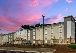 a large apartment building with a cloudy sky at WoodSpring Suites Roanoke in Roanoke
