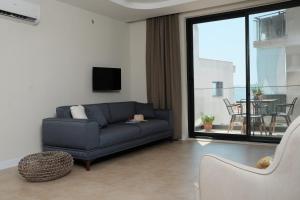 a living room with a blue couch and a balcony at Kaktus Suites in Kas