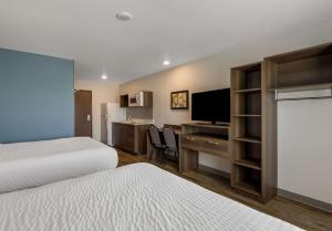 a hotel room with two beds and a desk with a computer at WoodSpring Suites Roanoke in Roanoke