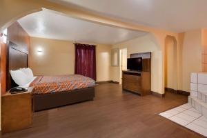 une chambre d'hôtel avec un lit et une télévision dans l'établissement Rodeway Inn & Suites East, à La Nouvelle-Orléans
