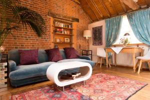 sala de estar con sofá azul y pared de ladrillo en Snow Cottage laid back style with footpaths to a great Macro Brewery Pub 