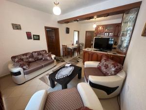 sala de estar con sofá, mesa y TV en Guri Guest House, en Pogradec
