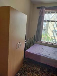 een slaapkamer met een bed en een raam bij Paradise Apartment- Female Only in Bradford