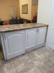 a white kitchen island with a counter top at Paradise Apartment- Female Only in Bradford