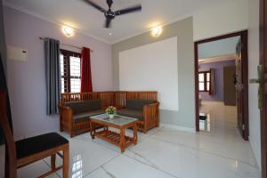 ein Wohnzimmer mit Couch und Tisch in der Unterkunft Lakeway Resorts in Alappuzha