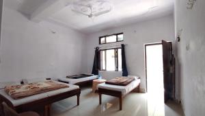乌德尔格希HOTEL PINE RESORT NETALA的有两张床和一扇窗户的房间