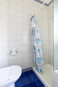 bagno con tenda per la doccia e servizi igienici di Casa Flores - 2 camere Padova a Padova