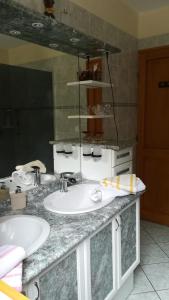 Baño con 2 lavabos y espejo en Chambres d'hôtes Chez Dumitra en Calès