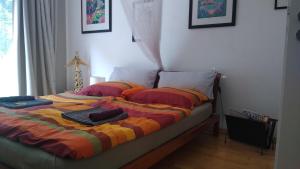 a bed with a colorful blanket on top of it at Rob´s Place in Langenfeld