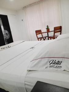 Schlafzimmer mit einem Bett, einem Tisch und Stühlen in der Unterkunft Hotel Saint John in Medellín