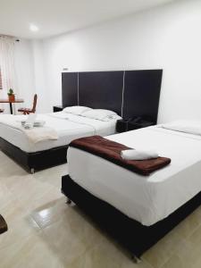 2 Betten in einem Hotelzimmer mit 2 Schlafzimmern in der Unterkunft Hotel Saint John in Medellín