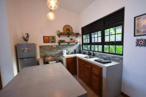a kitchen with a sink and a refrigerator at Private Villa at the Source of the Nile in Jinja