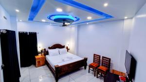 1 dormitorio con 1 cama y techo azul en Grand Periyar Residency,Near Kumily Busstation, en Thekkady
