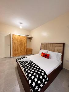 a bedroom with a black and white comforter on a bed at Shawell Homes in Kilifi