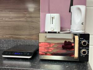 a microwave with a toaster and a coffee maker at Star Apartments in Manchester