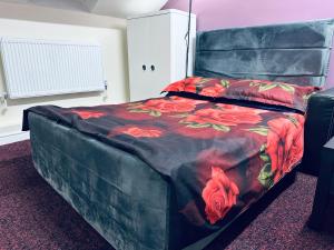 - une chambre avec un lit orné de fleurs rouges dans l'établissement Star Apartments, à Manchester