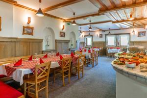 a restaurant with tables with red napkins on them at Hotel Krvavec in Cerklje na Gorenjskem +49 photos