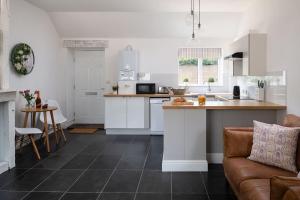 a kitchen with white cabinets and a counter top at Little Calf Cottage in Malmesbury