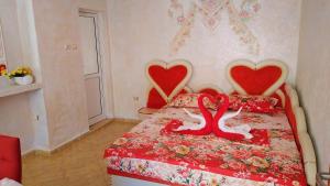 a bedroom with a bed with two hearts on it at Boutique Guest House 'Sofia' in Nesebar