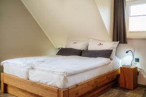 a bedroom with a bed with white sheets and a window at Baude III - Löwenbaude Braunlage in Braunlage
